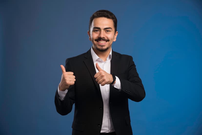 A businessman in a suit giving a thumbs up.